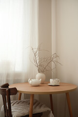 A serene minimalist setup with a wooden table, stylish teapot, and natural decor accents enhancing...