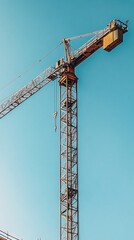 Naklejka premium Construction crane at a building site under a clear blue sky