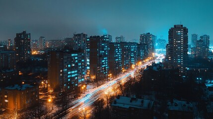 Obraz premium Nighttime cityscape view with illuminated buildings and streaks of moving car lights