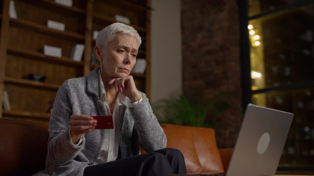 Senior woman worried about online payment with credit card