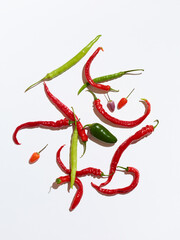 Green and red chili peppers on white background