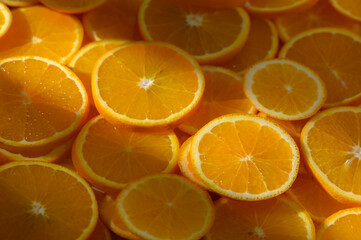 Fresh slices of vibrant oranges basking in sunlight in a lively kitchen setting