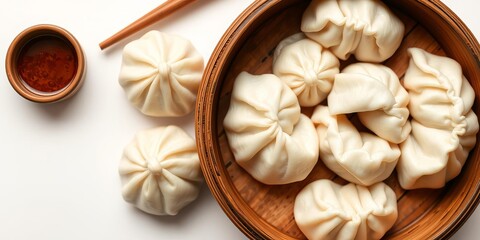 Chinese steamed buns and dumplings served on a brown bowl, traditional dim sum food on a white background, top view, Chinese cuisine, steamed buns