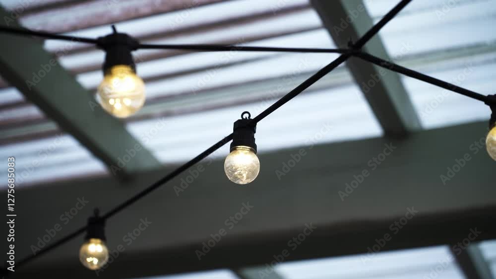 Poster lit string of lightbulbs hanging from the ceiling. selective focus shot