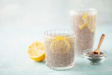 Chia seed water in drinking gasses with lemon slices on wooden table. Drink for a healthy diet