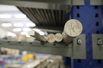 A collection of various metal rods is currently resting on a shelf within a large warehouse facility dedicated to industry operations