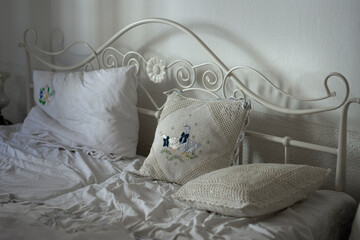 Romantic linen with hand embroidery on a white cast iron bed