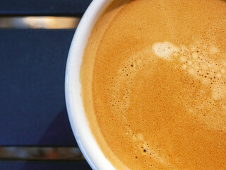 Coffee cream texture of fragrant coffee in a cup with delightful coffee colored bubbles with foam. macro coffee crema