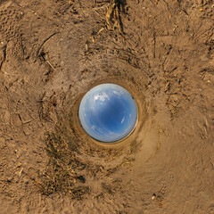 blue hole sphere or globe little planet inside grass or sand or dry ground frame background with tractor tracks