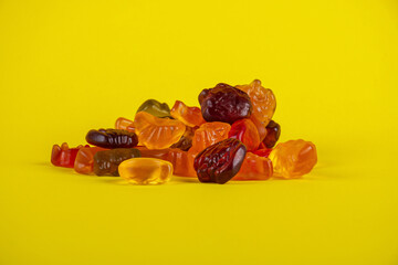 Fruit flavored worm shape, jelly candies Isolated on yellow background.