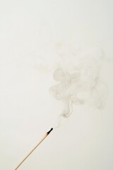 Yearly cough with smoke rising from a match against a minimalist white backdrop