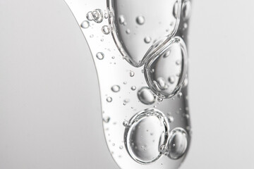 Transparent cosmetic texture with bubbles on a gray background, hyaluronic acid, macro gel.