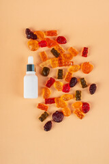 Plastic white tube for cream or lotion. Skin care or sunscreen cosmetic with stylish props and fruit gummi on cream background.