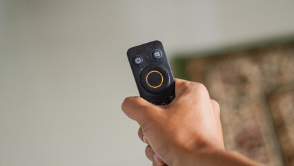 photo of close up television remote. concept of hand holding television remote