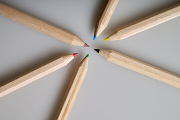 Six raw wooden colored pencils on white background
