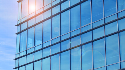 Modern stylish architecture. Symmetrical blue glass building in the city. Cityscape office...