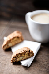 Cantuccini (Italian cookie) and a cup of coffee on dark wooden background. Close up.
