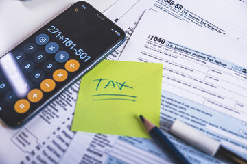 Accountant calculating taxes using calculator app on smartphone