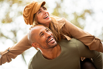 couple shares a joyful piggyback ride outdoors