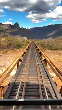 Train crossing scenic bridge in Durango, Mexico, with mountains and blue sky