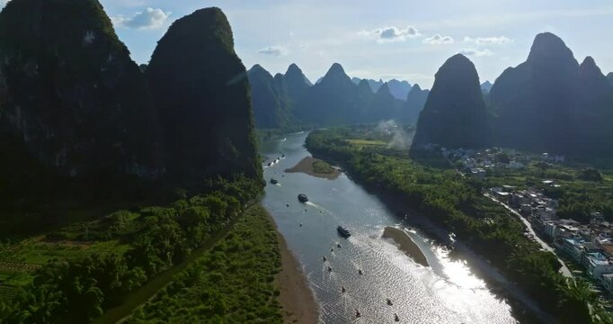 Aerial view tracking Li river sightseeing boats driving between mountains in China