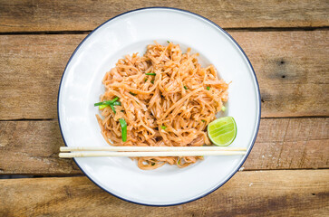 Delicious plate of pad thai with lime and chopsticks