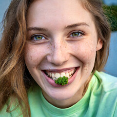 "The imperfect beauty": Junge, natürliche Frau mit Sommersprossen, Zahnspange und Petersilie zwischen den Zähnen.