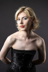 Fototapeta premium Expressive young blonde under a bob in the studio. In a black corset and dress.