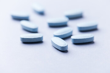Multivitamin tablets on bright paper background. Close up. Copy space	