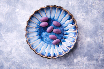 Lutein tablets. Dietary supplement on wooden background. Soft focus. Top view. Close up. Copy space