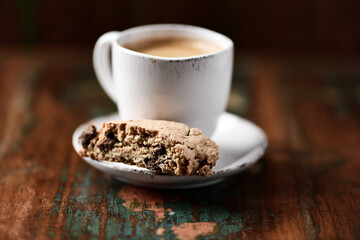 Cantuccini (Italian cookie) and a cup of coffee on dark wooden background. Close up.