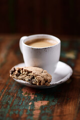 Cantuccini (Italian cookie) and a cup of coffee on dark wooden background. Close up.	