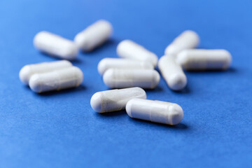 Tyrosine capsules (one of the 20 standard amino acids). A dietary supplement used to improve attention and focus on paper background. Soft focus. Close up.	