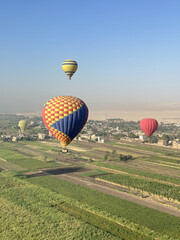 Obraz premium Aerial view of the crops on East bank with the hot air balloons in the morning, Egypt