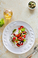 Mediterranean cuisine. Greek salad of tomatoes, cucumbers, feta cheese and herbs.