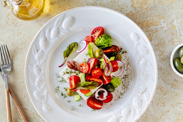 Mediterranean cuisine. Greek salad of tomatoes, cucumbers, feta cheese and herbs.