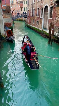 Venetian Canal: A traditional gondola glides gracefully along a serene canal, framed by charming historic buildings and a quaint bridge, capturing the essence of Venetian charm.