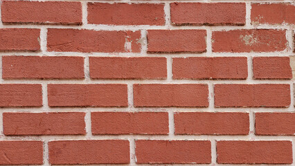 Red exposed fine clay brick wall texture reveals intricate details and natural hues, offering a rustic and visually appealing backdrop that enhances the character of any space