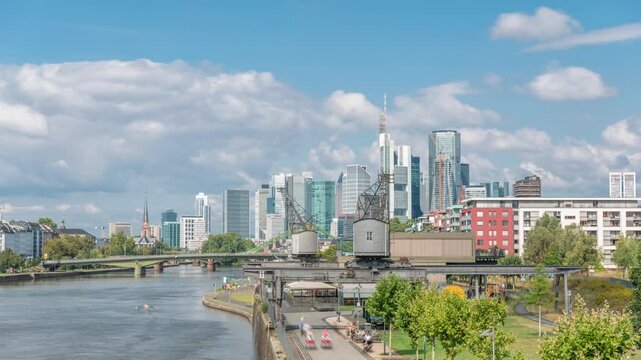 Hyperlapse of Frankfurt's Main Iron Footbridge (Flosserbrucke) against the financial district skyscrapers skyline on a sunny day with clouds timelapse. Frankfurt, Germany, financial hub of Europe