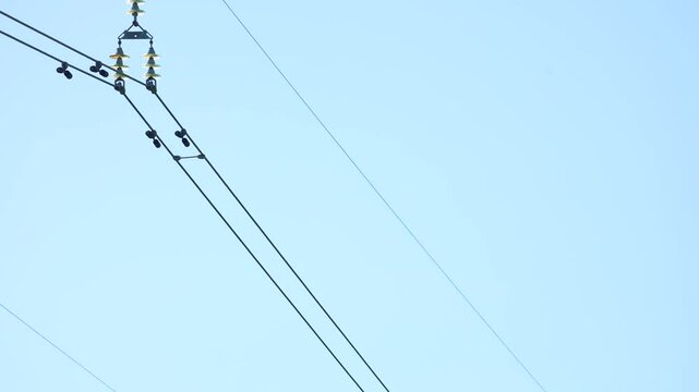 Utility Lineman Working on Cables high up to repair wires on a power pole.