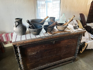 Rustic kitchen utensils on a wooden chest create a traditional interior ambiance