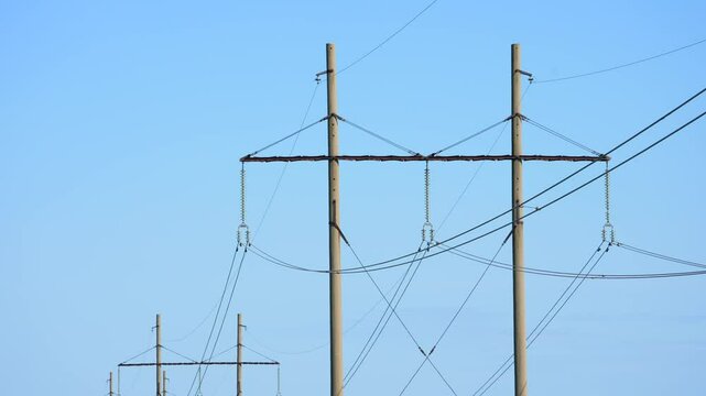 Electric power lines against the blue sky. High voltage cables