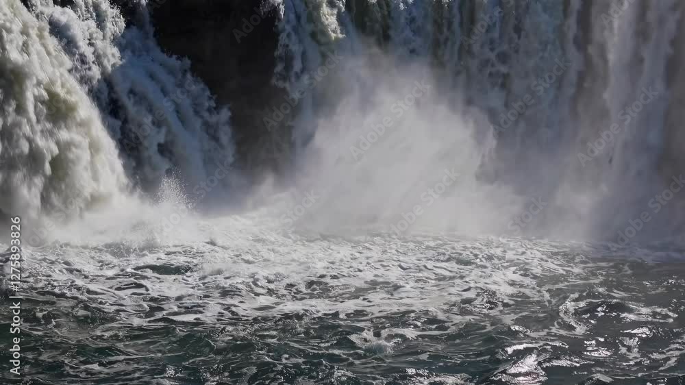 Poster dynamic video of a powerful waterfall captured from a low angle, emphasizing the force and majesty o
