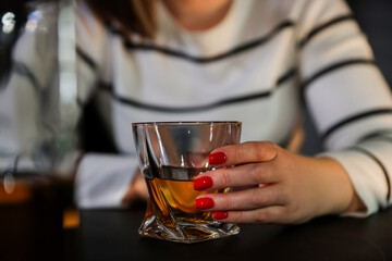 Alcohol addiction. Woman with glass of whiskey at table indoors, closeup