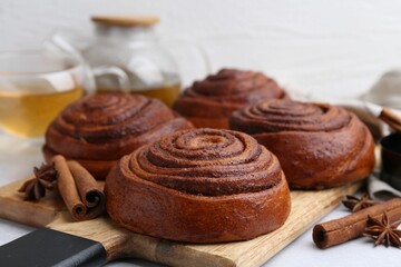 Delicious cinnamon roll buns on light table, closeup