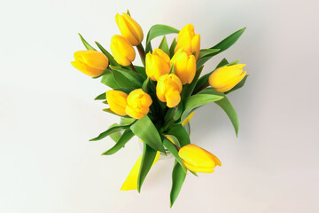 Bouquet of beautiful yellow tulips on white background, top view