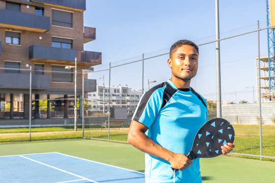 Young latino athlete playing pickleball on a sunny day: portrait of a confident player holding paddle