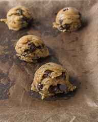 scoops of chocolate chip cookie dough on a baking sheet, homemade chocolate chip cookie dough,...