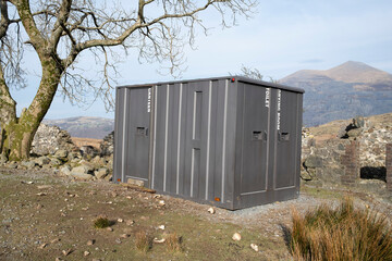 Metal utilities container by a derelict house