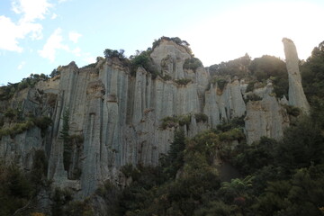 Dramatic limestone rock formations towering over lush vegetation in New Zealand. A striking geological wonder ideal for adventure and exploration photography.